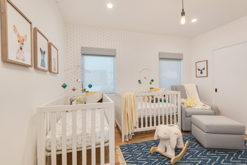 Réalisation d'une chambre de bébé garçon design de taille moyenne avec un mur blanc et parquet clair.