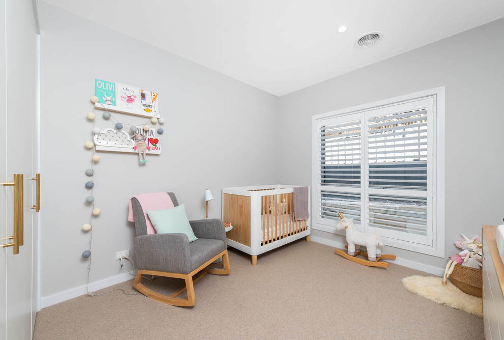 Esempio di una cameretta per neonati neutra contemporanea con pareti grigie, moquette e pavimento beige