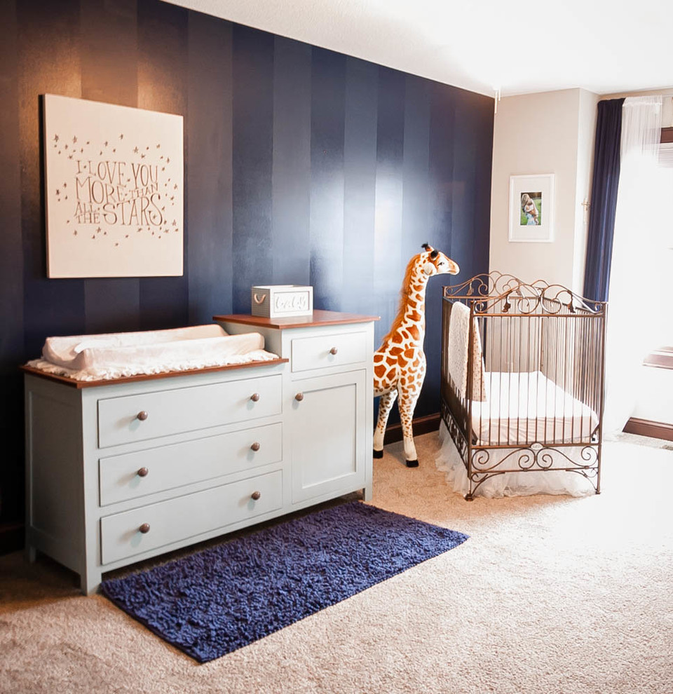 Aménagement d'une chambre de bébé garçon classique avec un mur bleu et moquette.