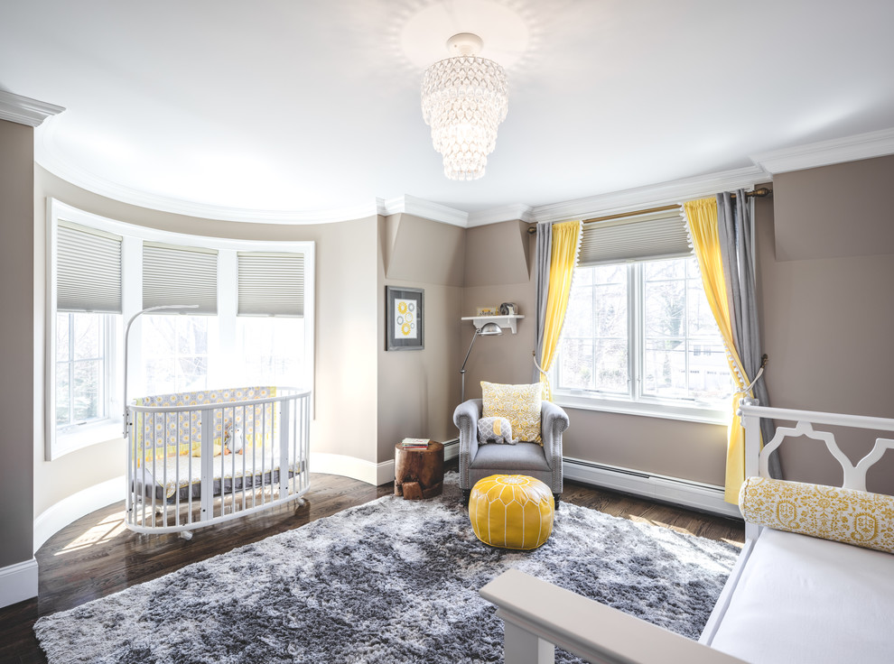 Imagen de habitación de bebé neutra clásica de tamaño medio con paredes beige, suelo de madera oscura y suelo marrón
