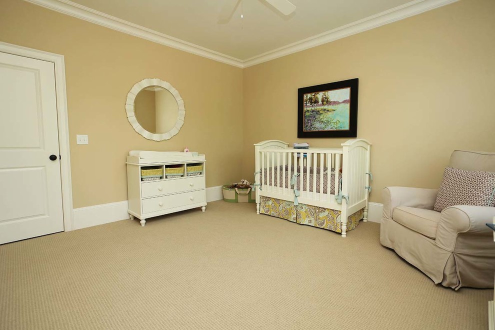 Cette image montre une grande chambre de bébé neutre traditionnelle avec un mur beige et moquette.