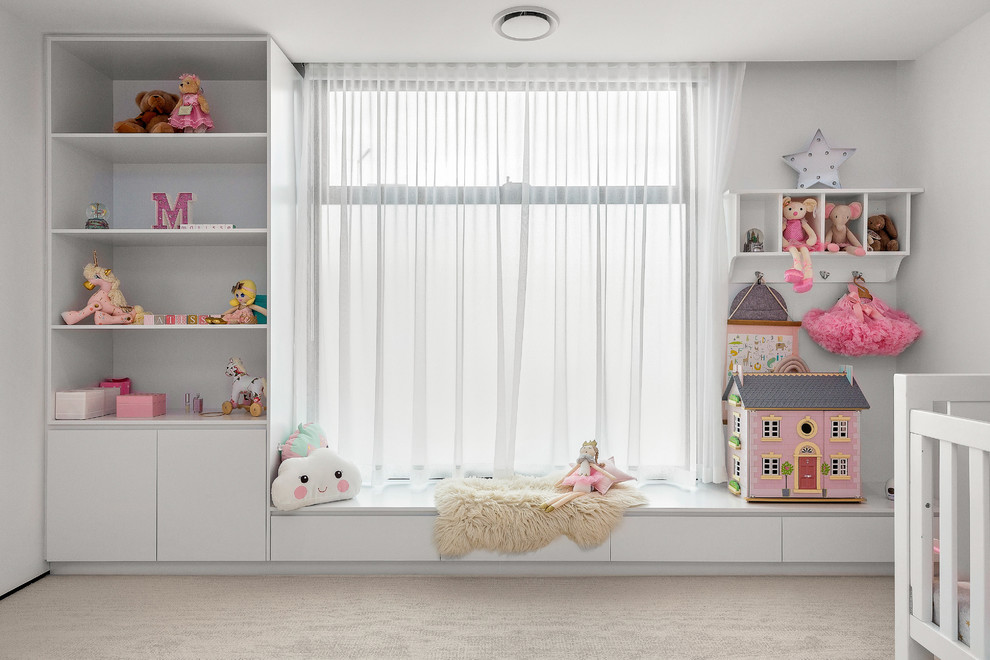 Immagine di una cameretta per neonata contemporanea di medie dimensioni con pareti bianche, moquette e pavimento bianco