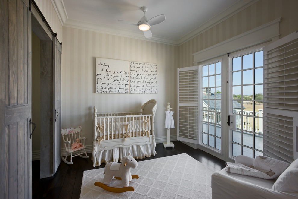 Ejemplo de habitación de bebé neutra tradicional de tamaño medio con paredes multicolor y suelo de madera oscura
