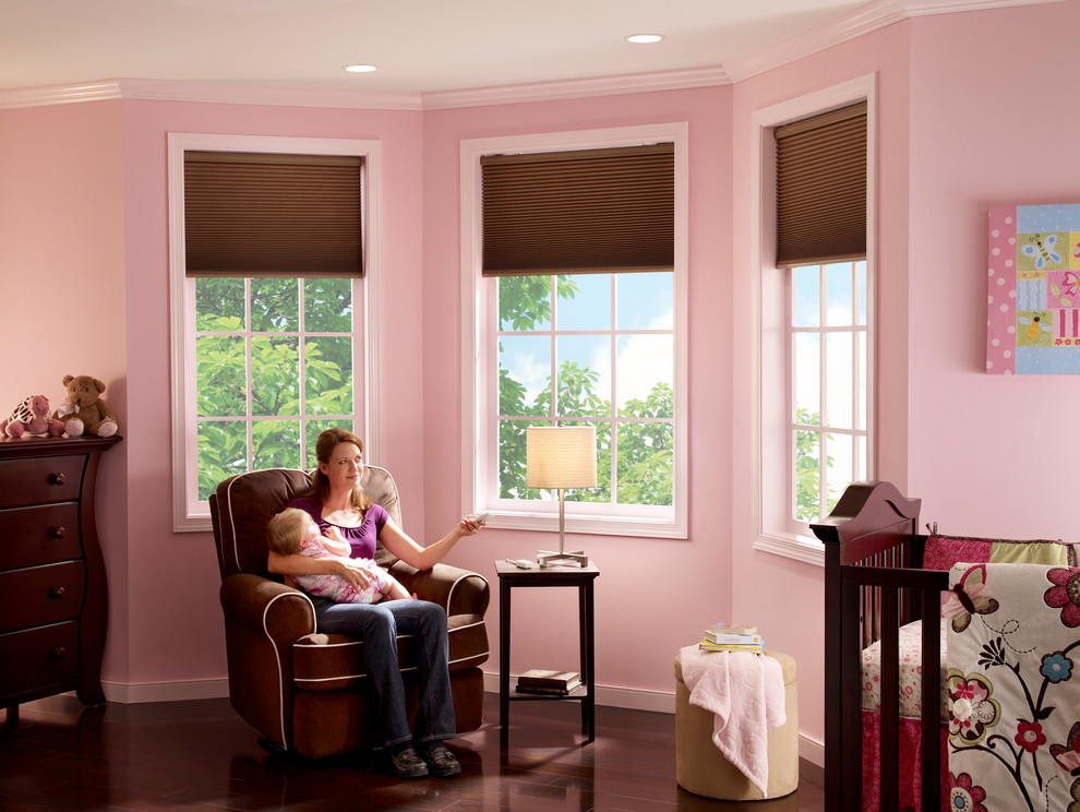 Foto de habitación de bebé niña clásica grande con paredes rosas y suelo de madera oscura