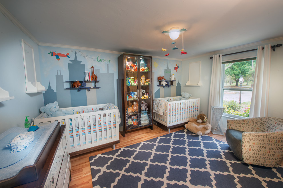 Idee per una cameretta per neonato tradizionale di medie dimensioni con pareti blu e parquet chiaro