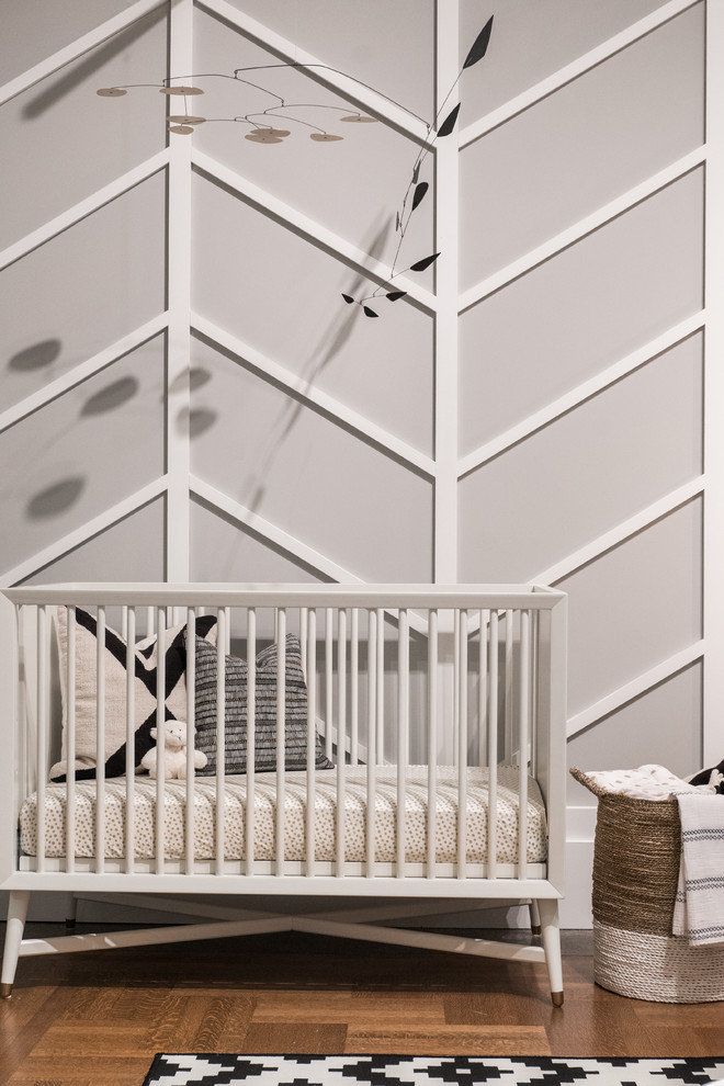 Inspiration pour une chambre de bébé neutre vintage de taille moyenne avec un mur gris, un sol en bois brun et un sol marron.