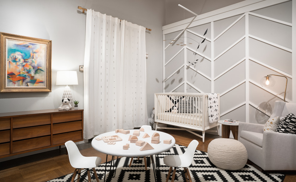 Idée de décoration pour une chambre de bébé neutre vintage de taille moyenne avec un mur gris, un sol en bois brun et un sol marron.