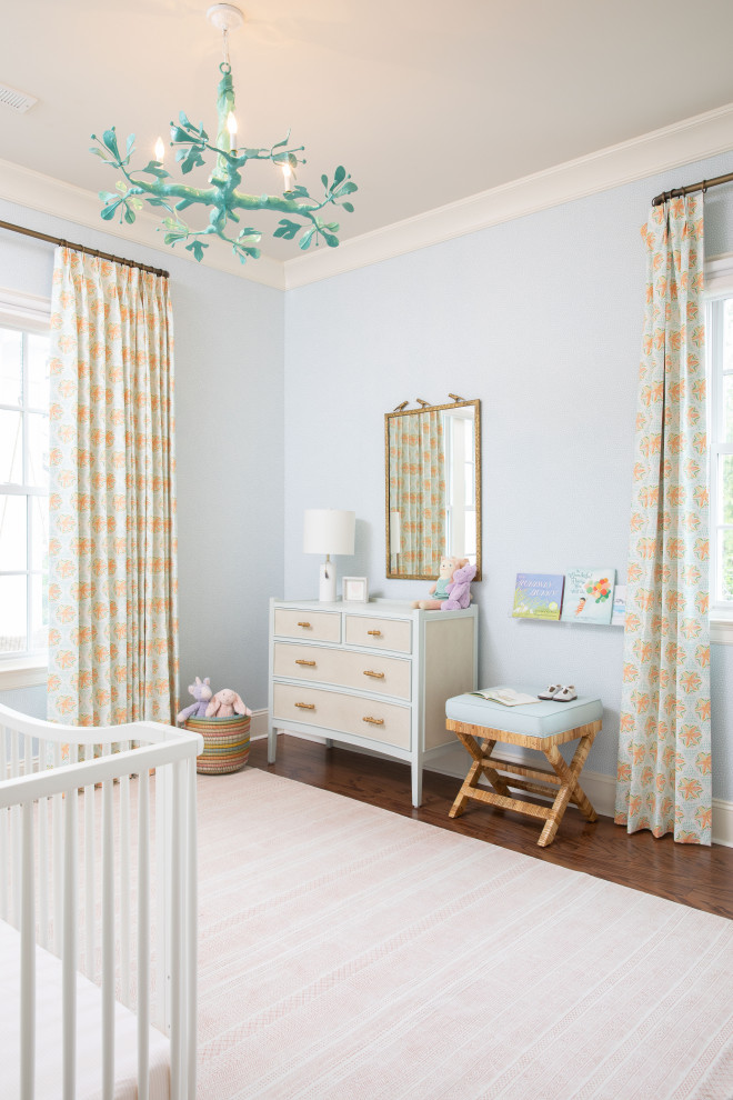 Réalisation d'une chambre de bébé neutre marine avec un mur bleu, parquet foncé et un sol marron.