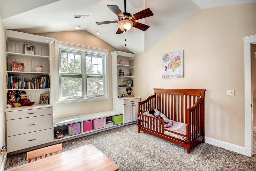 This is an example of a large classic nursery in Denver with beige walls, carpet and grey floors.