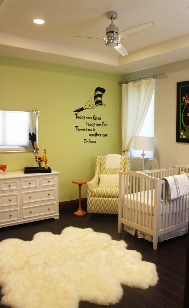 Ejemplo de habitación de bebé neutra actual con paredes grises, suelo de madera oscura y suelo marrón