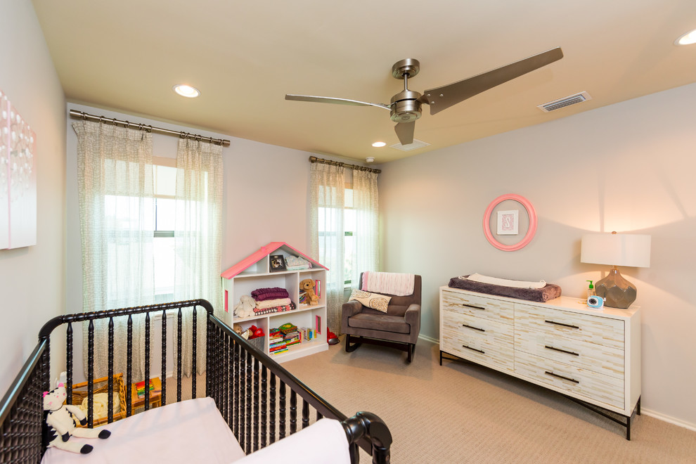 Modelo de habitación de bebé niña costera de tamaño medio con paredes grises y moqueta