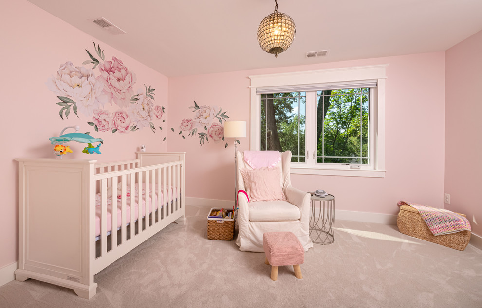 На фото: комната для малыша среднего размера в стиле неоклассика (современная классика) с розовыми стенами, ковровым покрытием и бежевым полом для девочки