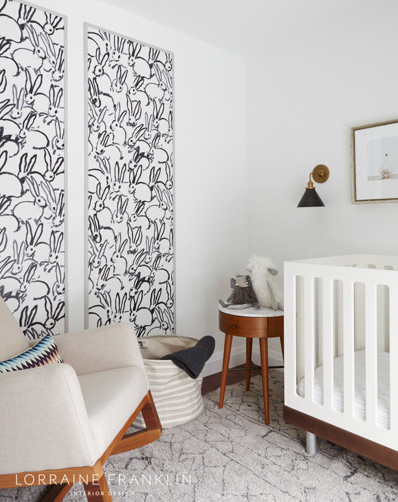 Ejemplo de habitación de bebé neutra clásica renovada pequeña con paredes blancas, suelo de madera clara y suelo beige