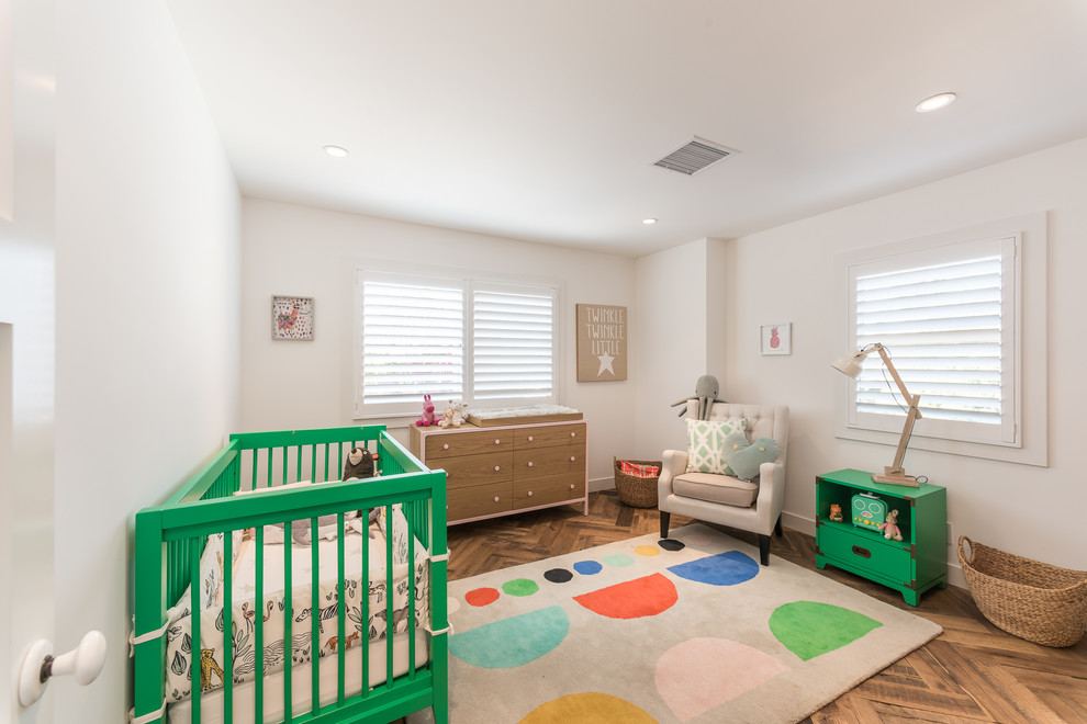 Design ideas for a medium sized retro gender neutral nursery in Los Angeles with white walls, medium hardwood flooring and brown floors.
