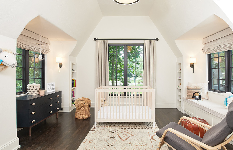 Imagen de habitación de bebé niña clásica renovada con paredes beige, suelo de madera oscura y suelo marrón