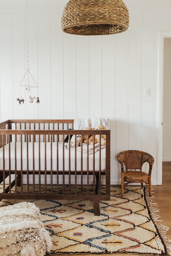 Стильный дизайн: нейтральная комната для малыша в скандинавском стиле с белыми стенами, паркетным полом среднего тона и коричневым полом - последний тренд