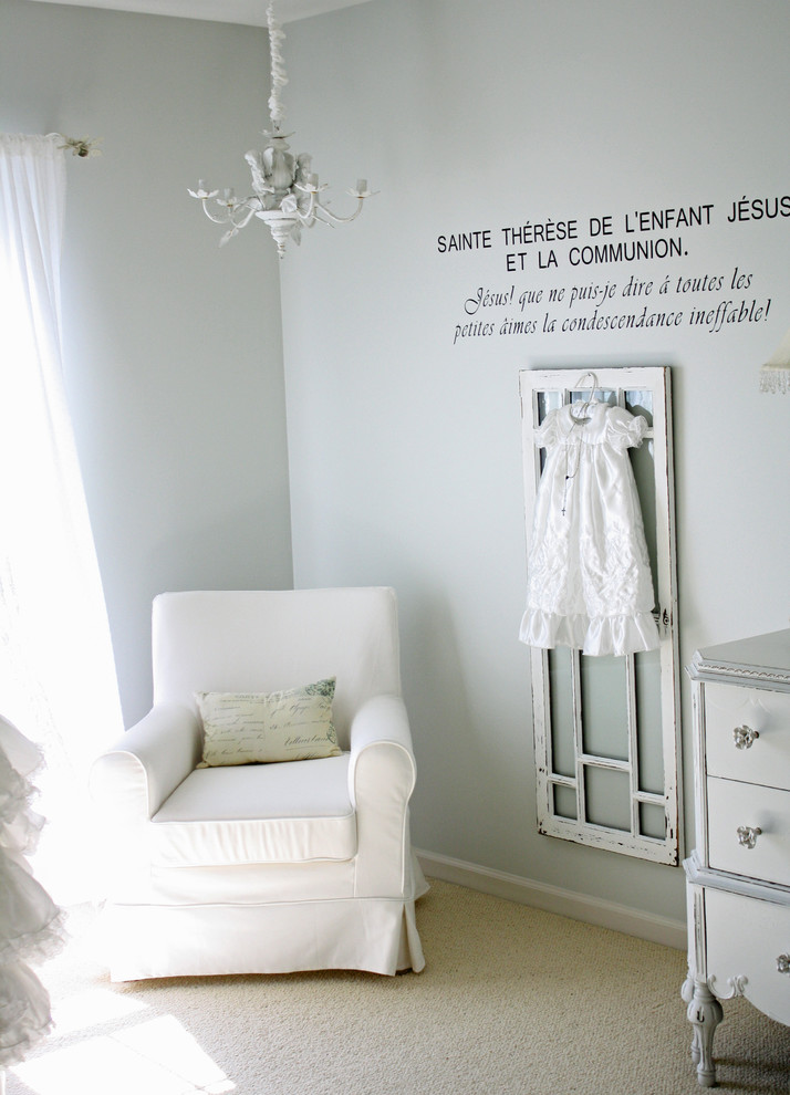 Diseño de habitación de bebé neutra bohemia con paredes grises y moqueta