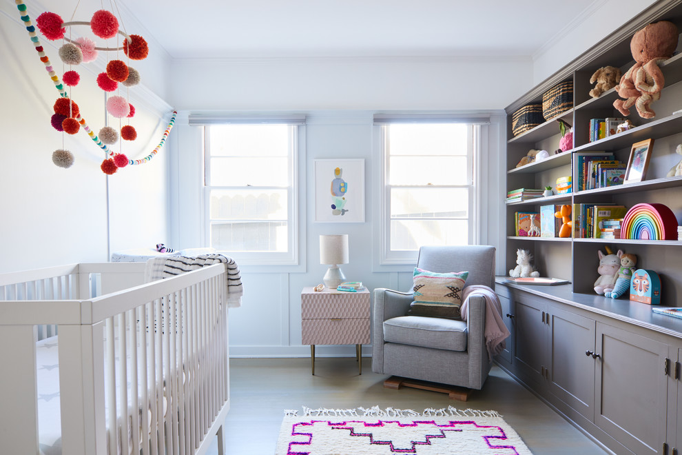 Nursery - small contemporary girl medium tone wood floor and brown floor nursery idea in Los Angeles with white walls