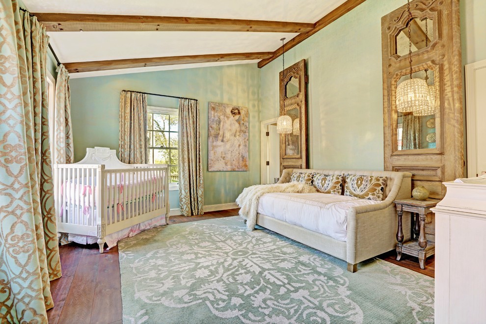 Réalisation d'une très grande chambre de bébé neutre tradition avec un mur vert et un sol en bois brun.