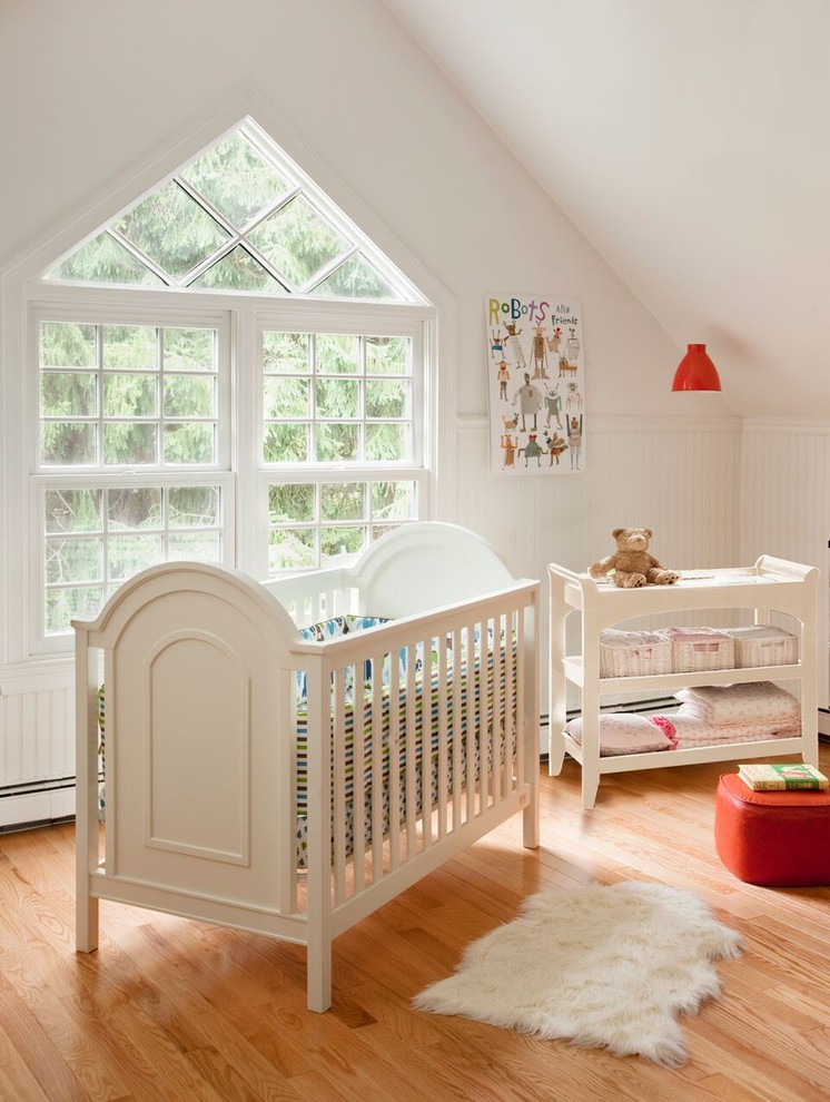 Foto di una cameretta per neonati neutra classica di medie dimensioni con pareti bianche e parquet chiaro
