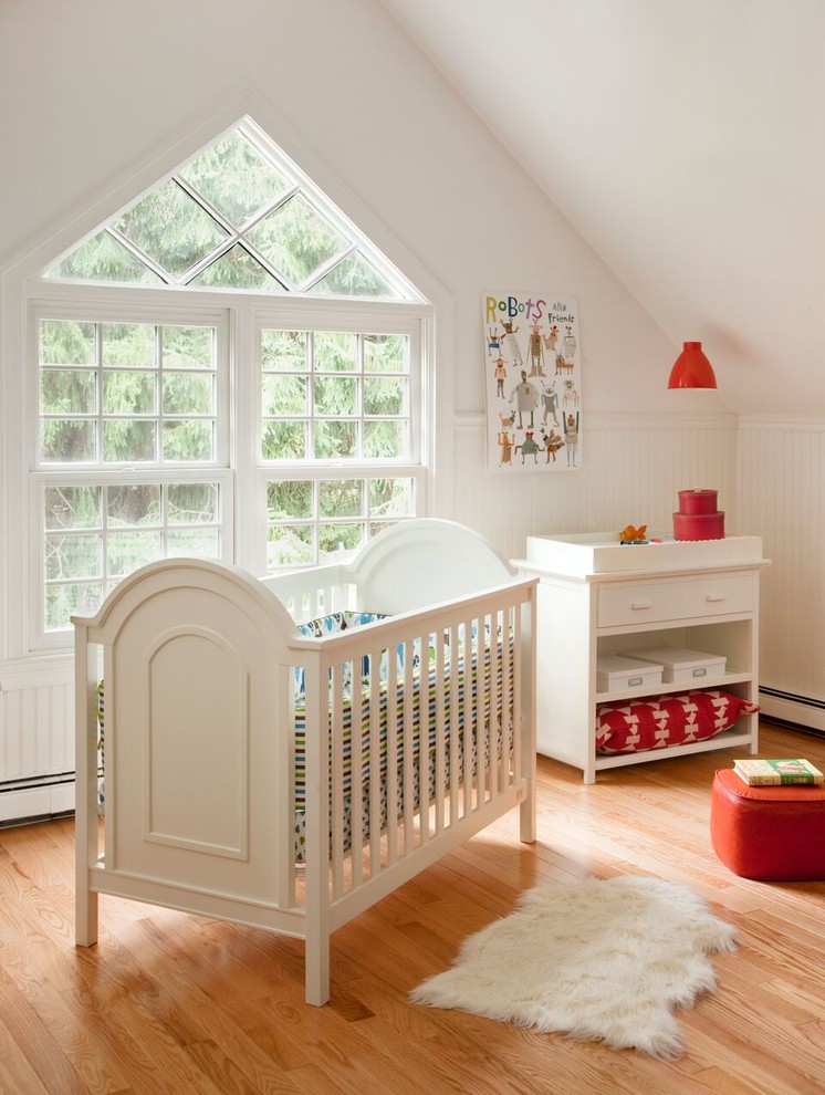 Foto de habitación de bebé neutra clásica de tamaño medio con paredes blancas y suelo de madera clara