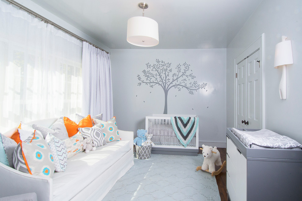 Imagen de habitación de bebé neutra tradicional renovada de tamaño medio con paredes grises y suelo de madera oscura