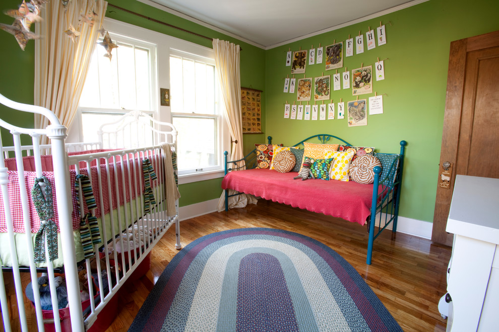 Diseño de habitación de bebé bohemia con paredes verdes