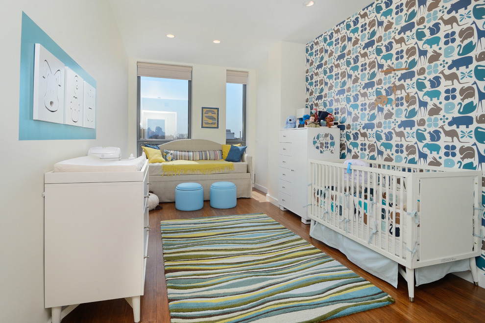 Mid-sized trendy boy medium tone wood floor nursery photo in New York with multicolored walls
