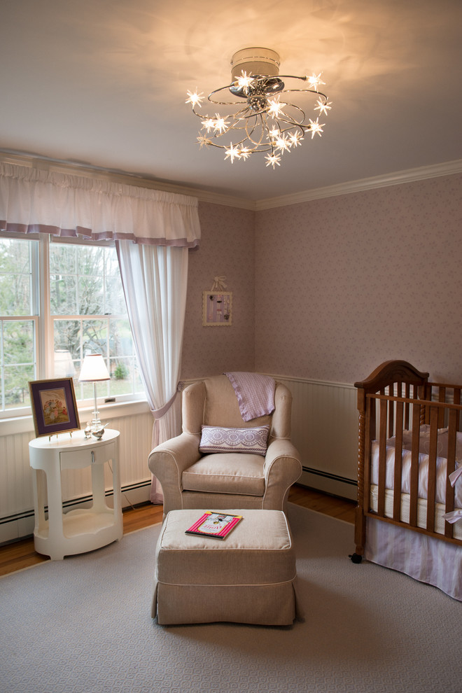 Design ideas for a medium sized traditional nursery for girls in New York with pink walls and medium hardwood flooring.