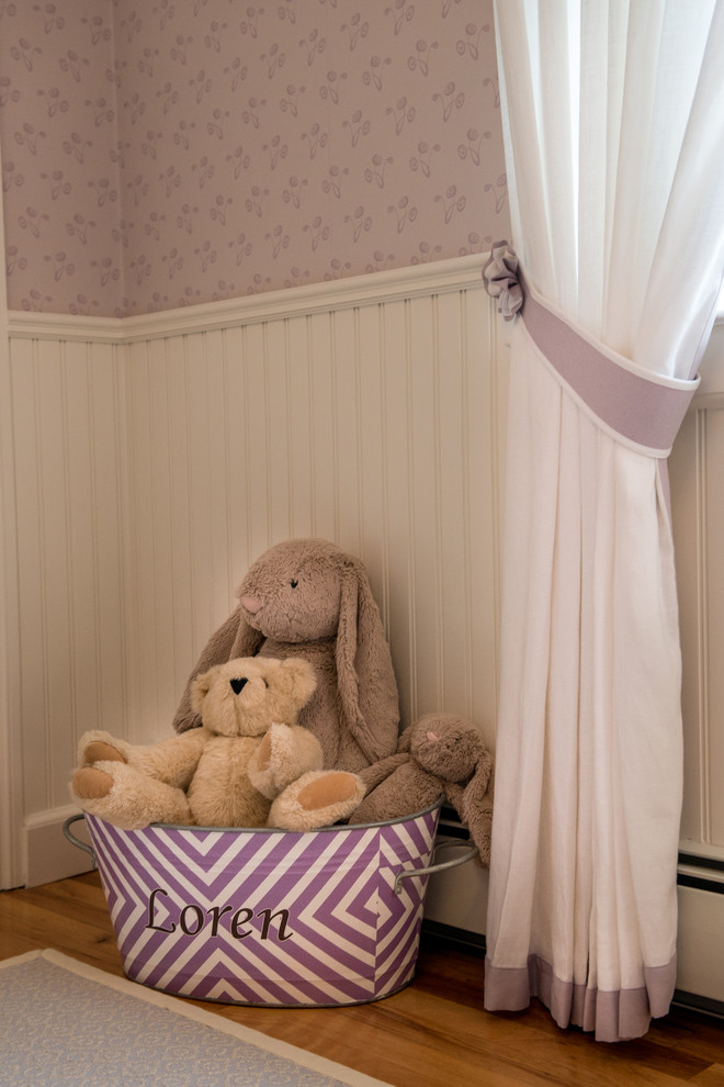 Ispirazione per una cameretta per neonata classica di medie dimensioni con pareti rosa e pavimento in legno massello medio