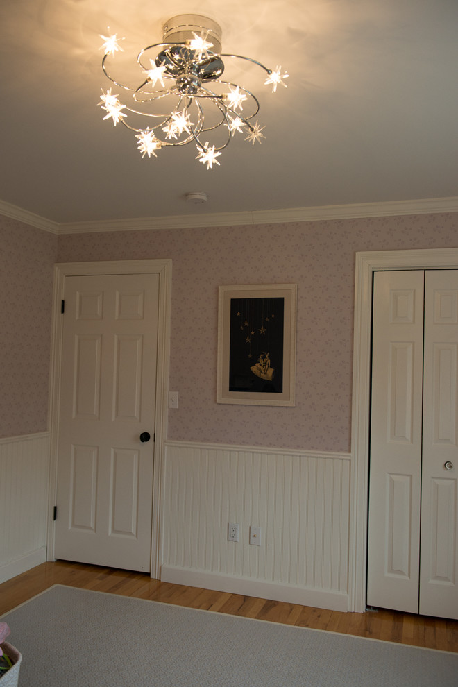 Design ideas for a medium sized traditional nursery for girls in New York with pink walls and medium hardwood flooring.