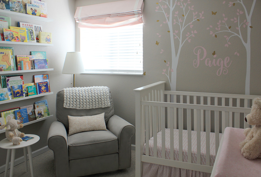 Immagine di una piccola cameretta per neonata con pareti grigie, moquette e pavimento beige