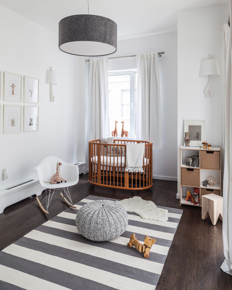 На фото: нейтральная комната для малыша среднего размера в стиле неоклассика (современная классика) с белыми стенами и темным паркетным полом с