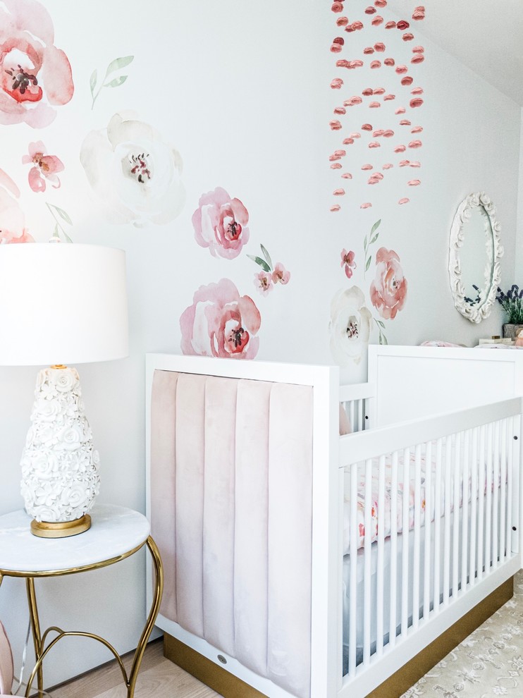 Medium sized traditional nursery for girls in New York with white walls, bamboo flooring and brown floors.