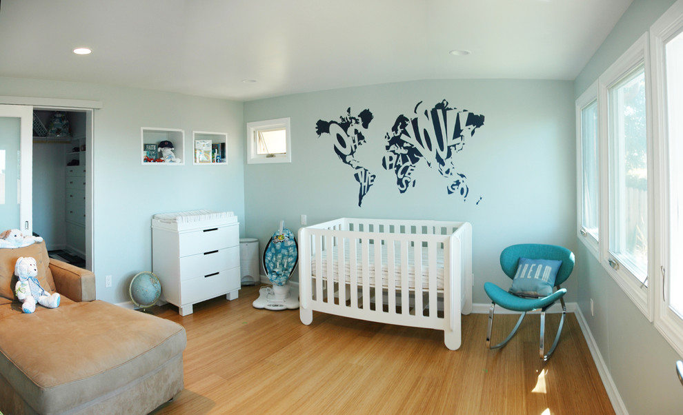 Foto på ett mellanstort funkis babyrum, med blå väggar och bambugolv
