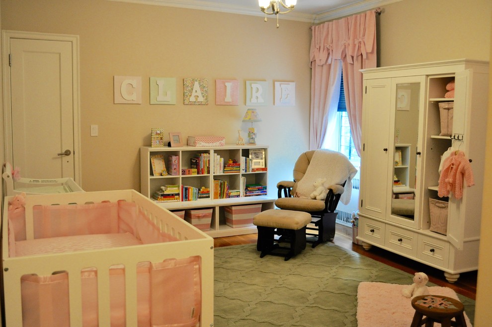 Immagine di una cameretta per neonata shabby-chic style di medie dimensioni con pareti beige e parquet chiaro