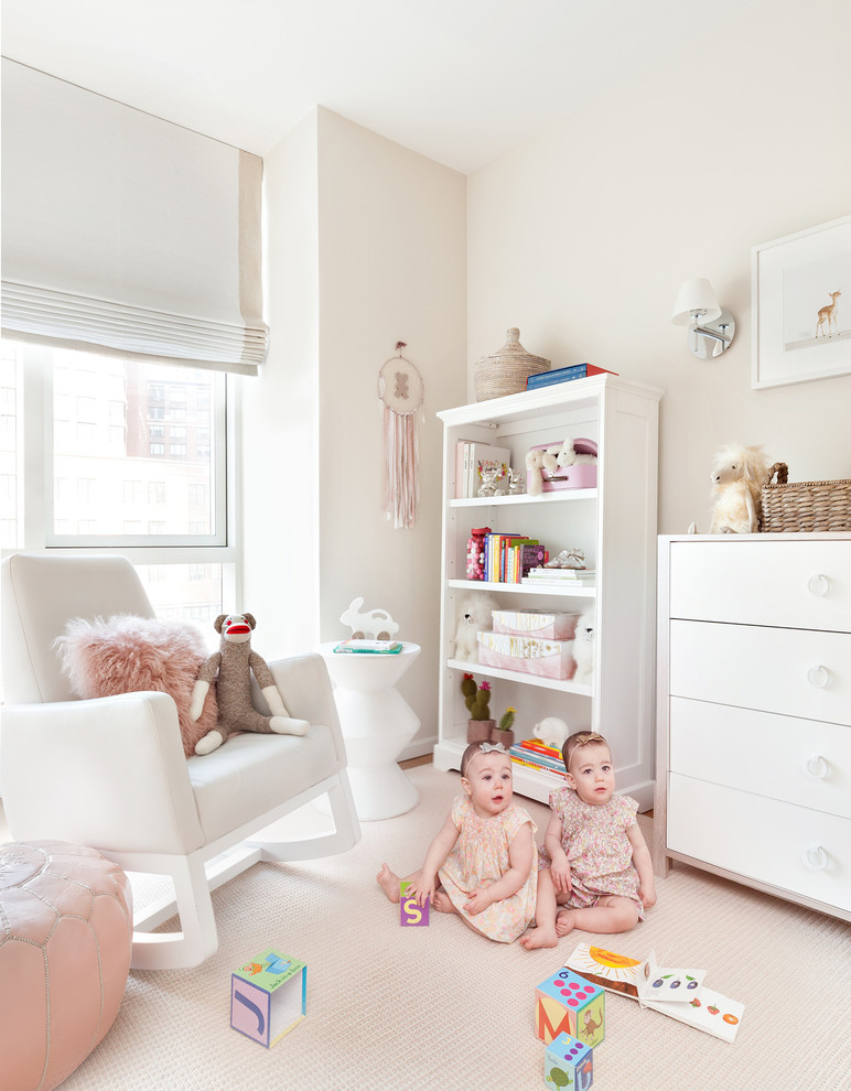 Immagine di una cameretta per neonata classica di medie dimensioni con pareti beige e pavimento in legno massello medio