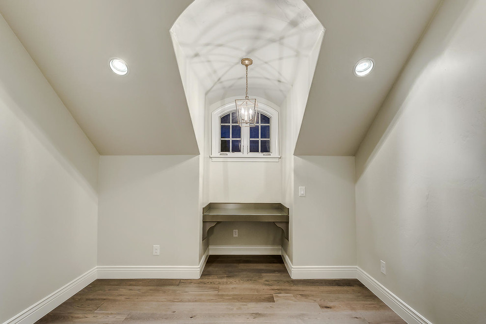 Esempio di una cameretta per neonati neutra tradizionale di medie dimensioni con pareti bianche, parquet chiaro e pavimento marrone