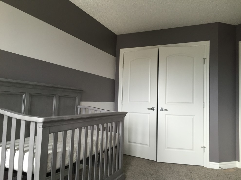 Modelo de habitación de bebé neutra tradicional renovada de tamaño medio con paredes grises, moqueta y suelo gris