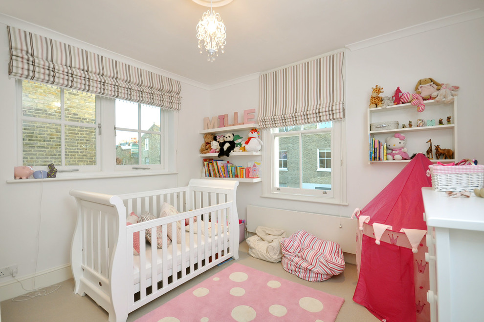 Photo of a classic nursery for girls in London with white walls and carpet.