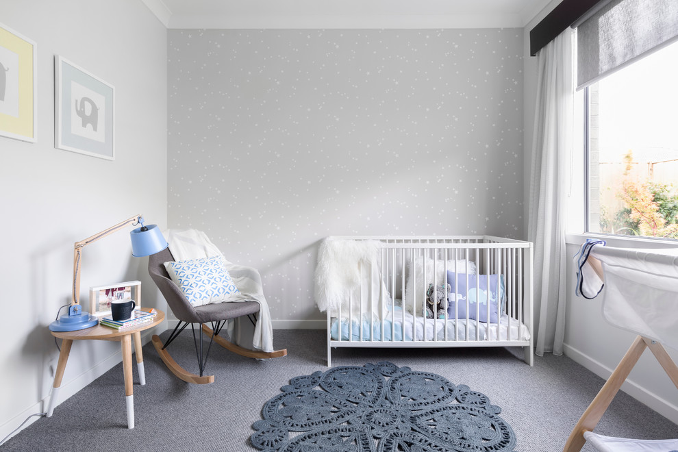 Foto på ett skandinaviskt könsneutralt babyrum, med grå väggar, heltäckningsmatta och grått golv