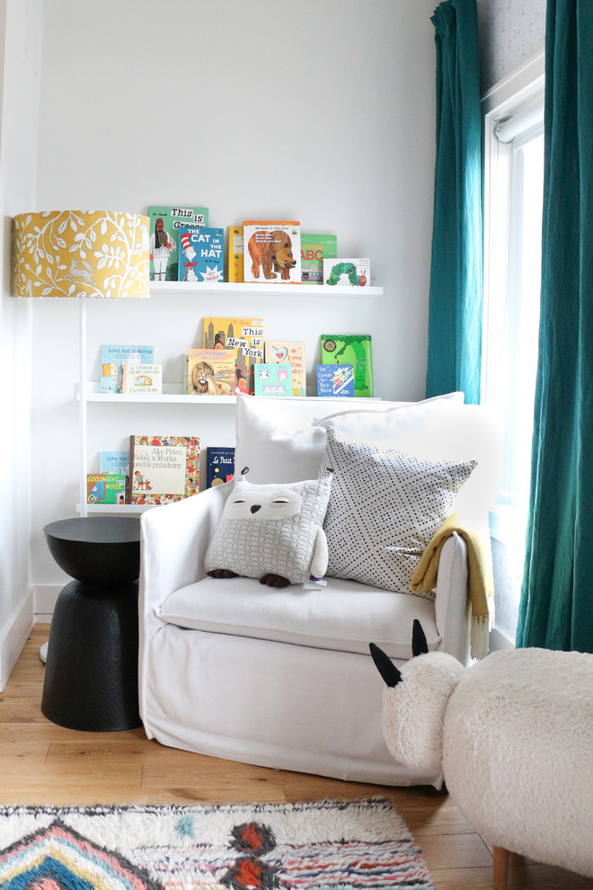 Exemple d'une chambre de bébé neutre moderne de taille moyenne avec un mur blanc, parquet clair et un sol beige.