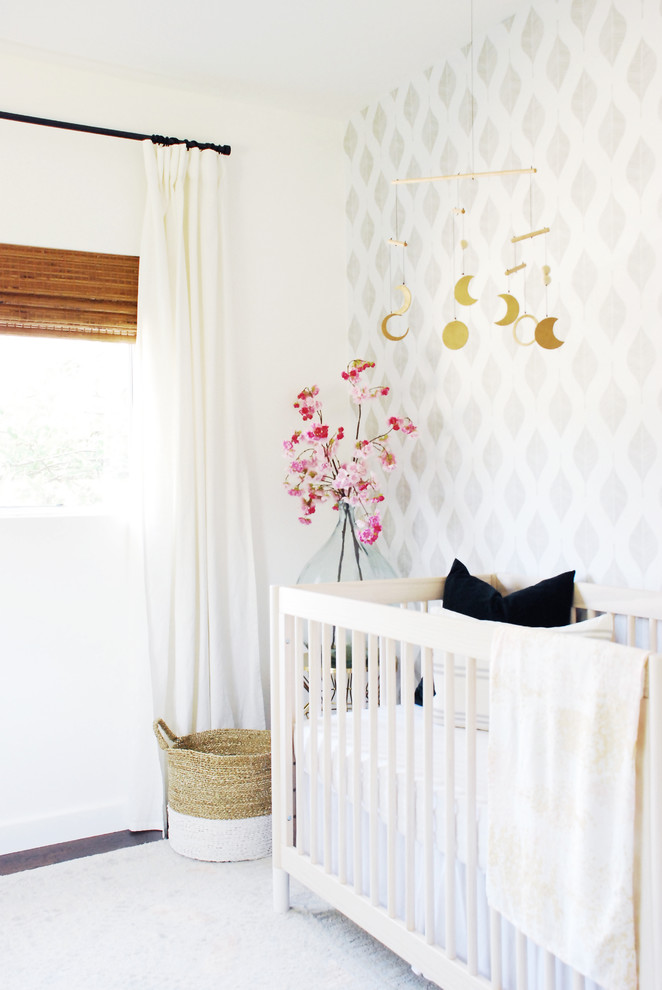 На фото: нейтральная комната для малыша в стиле неоклассика (современная классика) с полом из ламината, коричневым полом и серыми стенами с