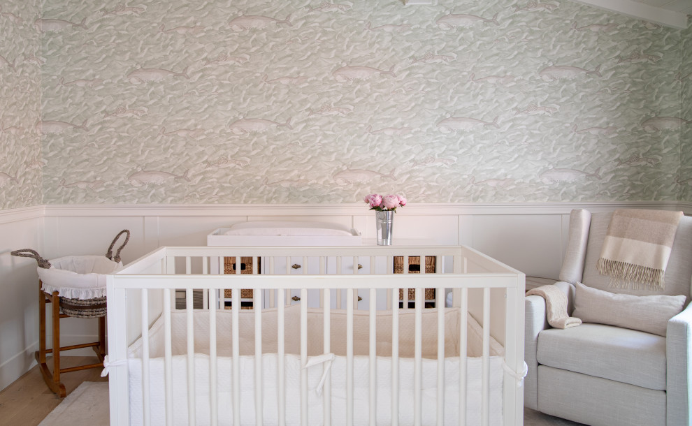 Modelo de habitación de bebé neutra clásica renovada de tamaño medio con paredes blancas, suelo de madera clara, suelo beige, vigas vistas y boiserie