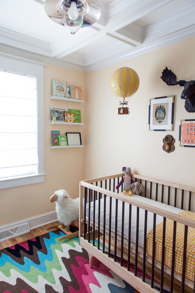 Inspiration pour une chambre de bébé neutre bohème avec un mur beige et un sol en bois brun.