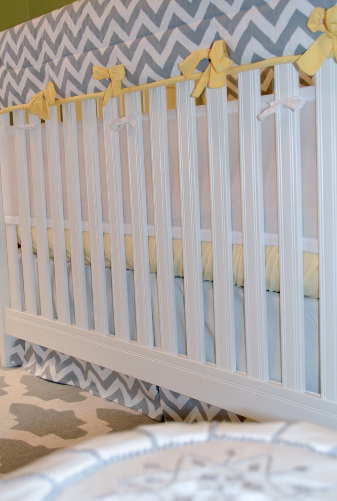 Modelo de habitación de bebé neutra tradicional renovada de tamaño medio con paredes verdes, suelo de madera en tonos medios y suelo gris