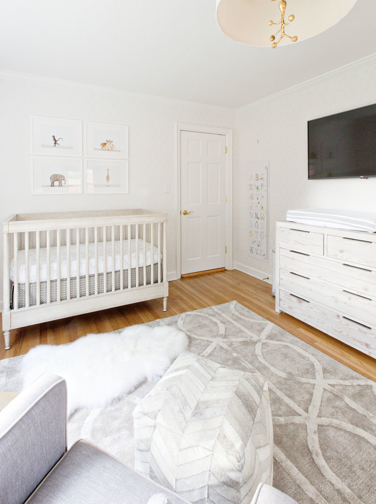 Foto de habitación de bebé neutra tradicional renovada de tamaño medio con paredes grises y suelo de madera clara