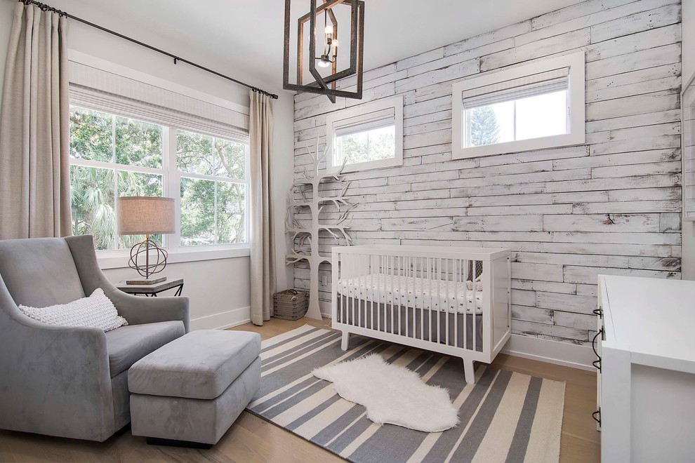 Idées déco pour une grande chambre de bébé neutre bord de mer avec parquet clair, un mur blanc et un sol beige.