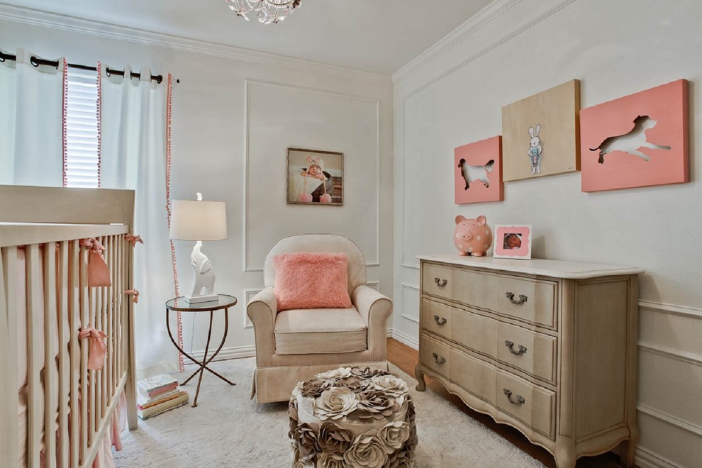 Exemple d'une chambre de bébé fille chic avec un mur blanc et un sol en bois brun.