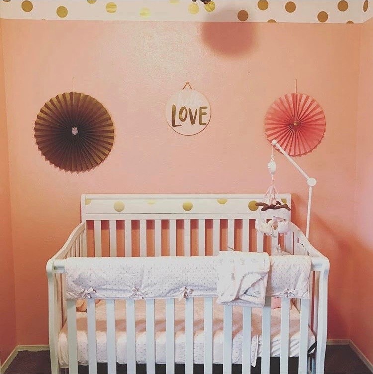 Immagine di una piccola cameretta per neonata minimalista con pareti rosa, moquette e pavimento beige
